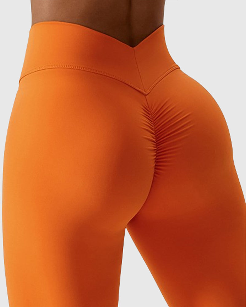 Leggings plisados ​​con costura en forma de V que moldean el cuerpo Pantalones de yoga para levantamiento de glúteos